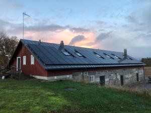 eine rote Scheune mit Solarpaneelen auf dem Dach in der Unterkunft Hotel Stallbacken Nagu in Nauvo