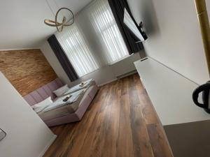 uma sala de estar com uma cama e uma grande janela em Gästehaus die Erfurter em Erfurt