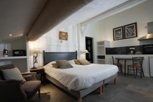 a bedroom with a large white bed and a kitchen at Auberge De La Poulcière in Gérardmer