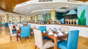un restaurante con mesas y sillas y un bar en Villa Del Palmar Flamingos Beach Resort & Spa, en Nuevo Vallarta 