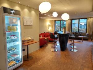 un ristorante con bar con sgabelli e frigorifero di Weissbad Lodge a Weissbad