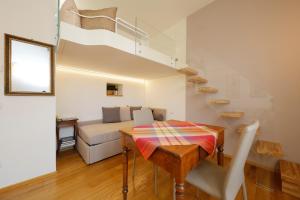 een woonkamer met een tafel en een trap bij Siena UpTown - Sabrina's Cozy Apartment in Siena