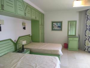 Marena Hurghada في الغردقة: غرفة نوم بسريرين مع دواليب خضراء