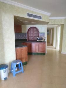 a kitchen with wooden cabinets and a blue stool at Marena Hurghada in Hurghada