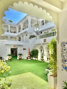 un gran edificio blanco con un patio verde en Jagat Niwas Palace, en Udaipur