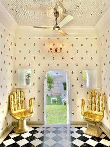 a living room with two chairs and a checkerboard floor at Jagat Niwas Palace in Udaipur