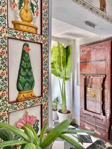 une chambre avec une photo d'un arbre de Noël sur le mur dans l'établissement Jagat Niwas Palace, à Udaipur