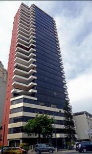 un edificio alto con coches estacionados frente a él en Apartamento de lujo Edif. El Fortin, en Guayaquil