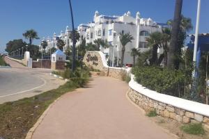 a walkway in front of a large white building at Superbe appart 3pieces a sania plage MARINA SMIR in M'diq