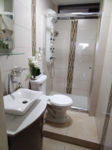 y baño con ducha, aseo y lavamanos. en Apartamento de lujo Edif. El Fortin, en Guayaquil