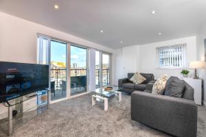 a living room with a couch and a tv at Just Stay Wales - Meridian Wharf, Marina View - 2 Bed Apartment in Swansea