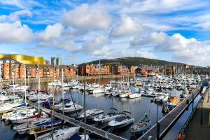 a bunch of boats docked in a marina at Just Stay Wales - Meridian Wharf, Marina View - 2 Bed Apartment in Swansea