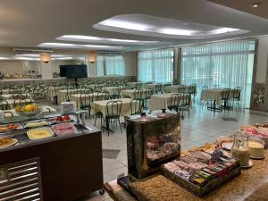 AQUARIUS HOTEL في بوتو فيلهو: قاعة احتفالات كبيرة مع طاولات وكراسي وطعام