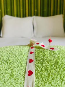 a bed with a red heart ribbon on it at Almograve Beach House in Almograve
