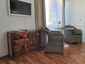 a living room with a tv and chairs and a table at Haus Achtern Diek in erster Reihe am Meer in Fehmarn +53 photos