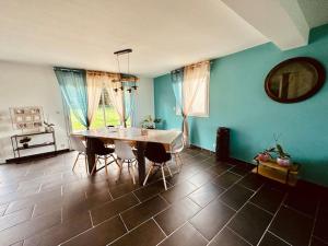 a dining room with a table and chairs and blue walls at Entre Nous in Vironchaux