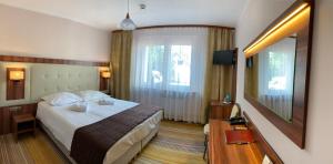 una camera d'albergo con letto e TV di Cumulus Hotel a Będzin