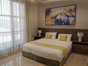 a bedroom with a large bed and two windows at شقة راقية بثلاث غرف نوم ودخول ذاتي in Riyadh