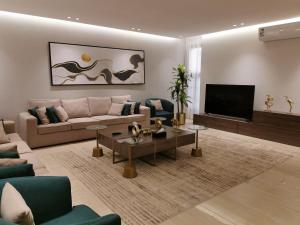 ein Wohnzimmer mit einem Sofa und einem TV in der Unterkunft شقة راقية بثلاث غرف نوم ودخول ذاتي in Riad
