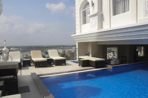 a swimming pool with chairs and a fireplace on a building at West Hotel in Can Tho
