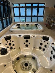 Cette chambre dispose d'une grande baignoire et de fenêtres. dans l'établissement 5min to Jonker Walk Town Area by De Avenue Stay, à Malacca