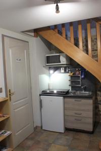 a small kitchen with a sink and a microwave at L'Escale du Banquet in Mhère