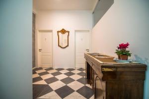 a room with a checkered floor and a table with a plant on top at Bed&Breakfast Salerno in Salerno