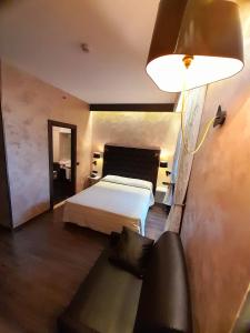 um quarto com uma cama, um candeeiro e um sofá em Hotel Continental em Turim