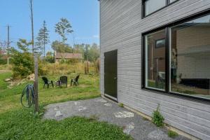 una casa con un patio con sillas y una ventana en Initial / Lagom / MSA, en Saint-Férréol-les-Neiges