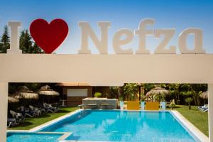 un cartello per un hotel con piscina di Hotel Alrawabi a Nefza