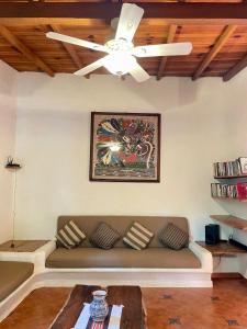 a living room with a couch and a ceiling fan at Casita Monarca in Troncones