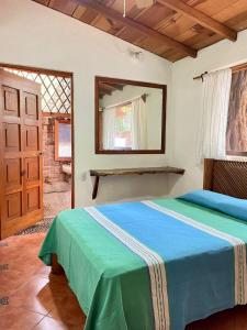 a bedroom with a bed and a window and a door at Casita Monarca in Troncones