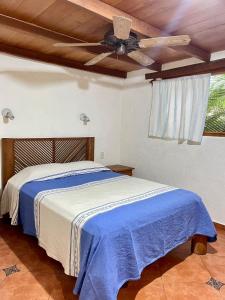Schlafzimmer mit einem Bett und einem Deckenventilator in der Unterkunft Casita Monarca in Troncones