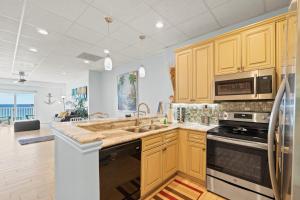 a kitchen with a sink and a stove top oven at Sans Souci 407 in Pensacola Beach