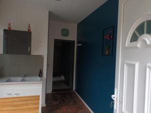 a kitchen with a sink and a blue wall at LA MEDINA in La Fère +18 photos