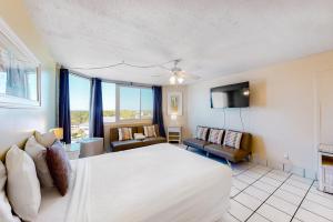 um quarto com uma grande cama branca e uma televisão em The Top of the Gulf #818 em Panama City Beach