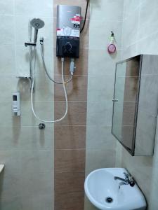 a bathroom with a shower with a sink and a mirror at MyHomestay07 in Kangar