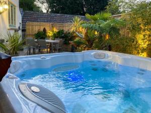 a hot tub in a backyard with a table and chairs at Pennyard House in Banwell