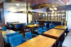 a restaurant with wooden tables and blue chairs at Keyonn Hotels & Resorts in Amritsar