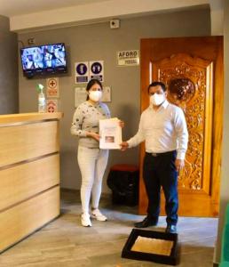 un hombre y una mujer con máscaras sosteniendo una caja en Hotel Las Terrazas De Caral, en Barranca
