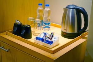 a wooden counter with a tea kettle and bottles of water at Keyonn Hotels & Resorts in Amritsar