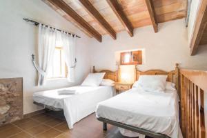 a bedroom with two beds and a window at Lletreres in Llubí