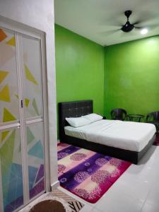 a bedroom with a bed and a green wall at MyHomestay07 in Kangar