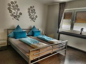 - une chambre avec un lit doté d'oreillers bleus et d'une fenêtre dans l'établissement Rhein - Mosel Quartier 4, à Boppard