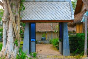 an outside entrance to a house with a thatch roof at Pai Vintage Garden Resort in Pai
