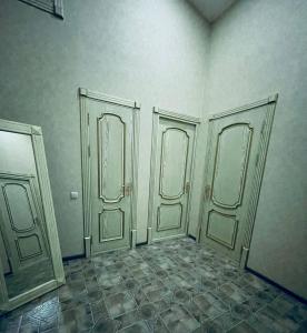 an empty room with two doors on a wall at Aleksandra Apartment in Samarkand