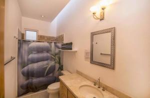 a bathroom with a sink and a toilet and a mirror at Casa Robyn in Cabo San Lucas