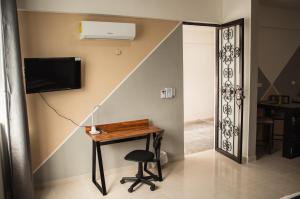 a room with a desk and a tv on a wall at Departamento Orellana 1 in Chetumal