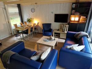 ein Wohnzimmer mit 2 blauen Sofas und einem Tisch in der Unterkunft Huuske 086 in Simpelveld