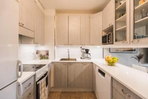 uma cozinha com armários de madeira e uma tigela de fruta no balcão em Penthouse with Sauna - King Size Bed - Free WiFi! em Rovaniemi
